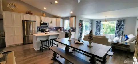 Bask in the light-filled elegance of this open-concept living, dining, and kitchen space—where canal views take center stage. Crisp white cabinetry, stainless steel appliances, designer glass tile backsplash and a spacious island invite easy entertaining, while the warm wood tones and panoramic windows blend coastal charm with everyday comfort. A perfect layout for soaking in Surfside serenity, indoors and out.