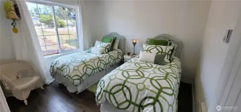 This cozy second bedroom offers a welcoming retreat and abundant natural light. It’s a bright and low-maintenance space that perfectly complements the home’s relaxed coastal style.