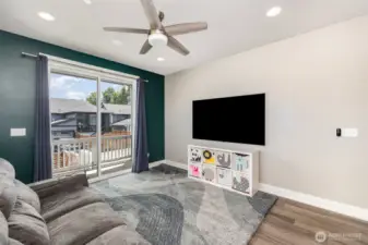 Living room features a built in home theater set-up including flush mounted 77" LG OLED Gallery Series Smart TV, Dolby Atmos 7.1 surround sound system with 5 wall speakers, 2 ceiling speakers.