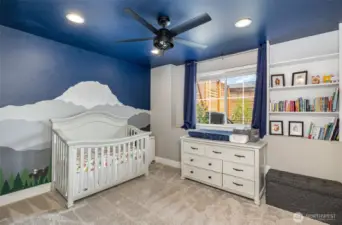 Charming downstairs guest bedroom showcases a custom mountain mural, ceiling fan, recessed lighting, and built-in shelving—perfect blend of style and function.