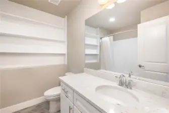 Downstairs full bathroom also boasts built-in shelving, quartz countertops, and a dedicated outlet for smart toilets or bidets.