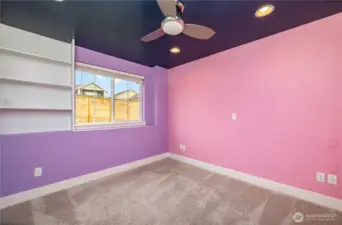 Second downstairs guest bedroom featuring ceiling fan, recessed lighting, and built-in shelving.