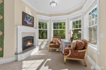 Sitting area in the primary bedroom surrounding a gas fireplace.