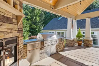 Outdoor kitchen with sink, BBQ, and cook-top burners.
