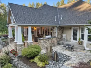 This angle shows the private patio with water feature and sitting area off of the primary suite.  Real wood Cedar siding.