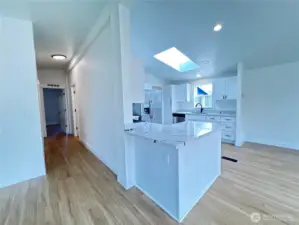 Great flow into the living area from the bedrooms. Hallway has doors for primary bedroom (end), secondary bedroom (left), and secondary bathroom (right).