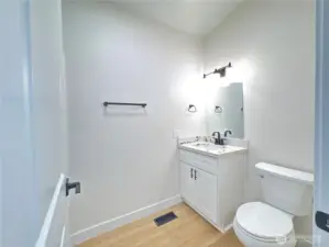 Secondary Bathroom. New cabinet, new quartz countertop, new mirror, new toilet, new light fixtures, new flooring.