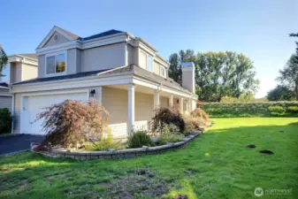 The end-unit townhome features a coverd walkway boardered by a professionaly landscaped garden.