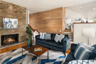 The open and airy living room occupies the north wing of the home. The remodeled stacked-stone fireplace is the centerpiece of the room and partners beautifully with the clear cedar wall treatment.