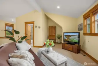 Room for everything in this bonus room. Full bath can be seen through the open door. Small alcove houses a desk. Sofa and TV round out the west side of the room.