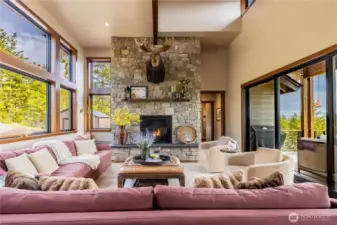 Living room has gas fireplace and high ceilings.