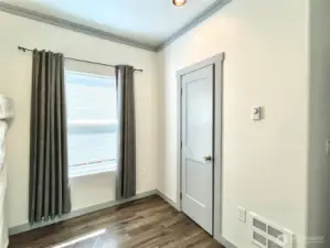 Front Bedroom and view of the window   facing streetside. Comfotable ceiling fan and   wall heater to keep you cozy