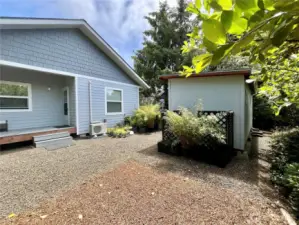View of the walk-in storage shed, back of home and Mini Split Heater/ AC unit by the deck steps