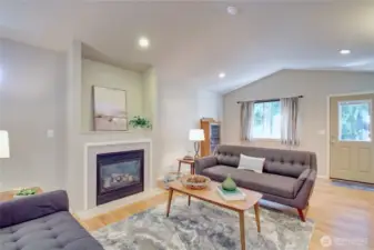 Living room with vaulted ceiling and cozy gas fireplace.