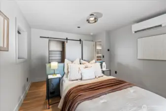 Lower level ADU bedroom features built-in headboard and water views