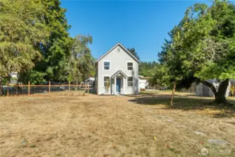 Classic two-story design with a welcoming blue door and simple farmhouse lines, showcasing the character of this 1910-built home.