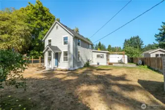 From this side view, you can appreciate the depth of the property with its mix of fenced areas and open yard—perfect for gardening, pets, or outdoor entertaining. The inviting deck offers plenty of space to relax or host gatherings.