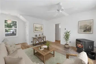 A cozy retreat anchored by a pellet stove, this room provides warmth and ambiance throughout the seasons. The clean lines of the 1910 architecture blend effortlessly with updated finishes, creating a timeless space for reading, relaxing, or enjoying quiet evenings by the fire. Newly painted .(Virtually Staged)
