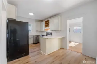 This functional kitchen offers ample counter space and cabinetry, complete with a breakfast bar for casual dining or entertaining. Natural light brightens the room, while its open layout flows easily into the adjoining dining area—an inviting blend of practicality and charm.