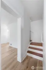 The staircase serves as a reminder of the home’s 1910 roots, blending warm wood steps with crisp white trim. This transitional space connects the main living areas with the private upstairs retreat, balancing old-world craftsmanship with modern updates.