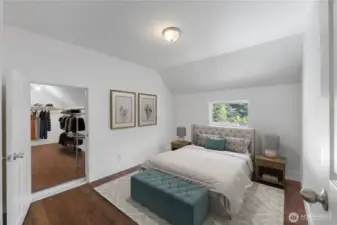Tucked upstairs, the spacious primary suite highlights the home’s historic charm with its angled ceilings and inviting design. The adjoining walk-in closet is a rare bonus for a home of this vintage, offering abundant storage alongside a private retreat filled with natural light. (Virtually Staged)