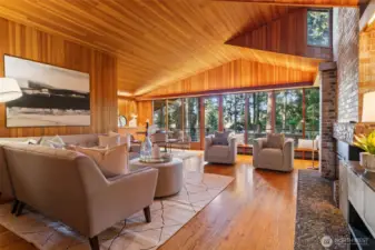 Great room with fir paneled walls, hardwood floors, vaulted ceilings.