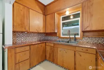 Recently updated custom copper countertops, beautiful glass tile, and a designer sink and faucet enhance the farmhouse charm of the kitchen.