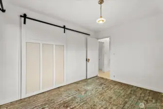 Main-floor bedroom refreshed with a new closet, barn door, and custom lighting.
