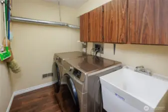 Laundry room w/ upper storage cabinets & utility sink.