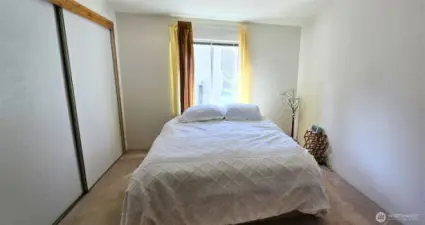 Primary bedroom with natural light and closet storage, offering a comfortable retreat
