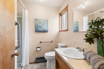 The ensuite bathroom for primary with shower & linen closet. Vinyl flooring.