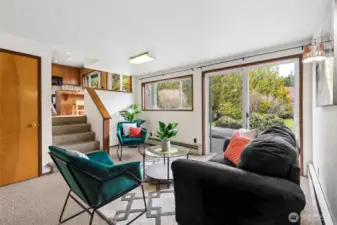 The family room is located on the main floor of the home. Steps in center to the upper split level lead to kitchen. Window & sliding glass door out to the back side of home with patio & yard. Door on the left leads to the unfinished basement.