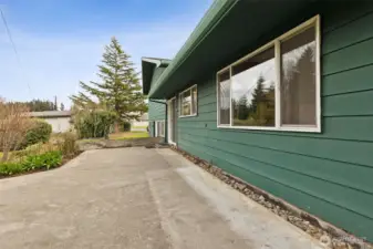 This patio on the upper split level wraps around to the covered patio area. Sliding glass door shown leads to the kitchen.