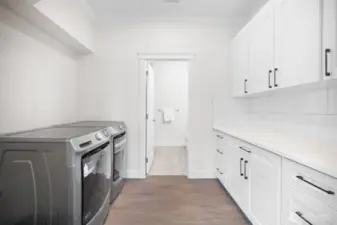 Open laundry room with plenty of storage make handling laundry a cinch!
