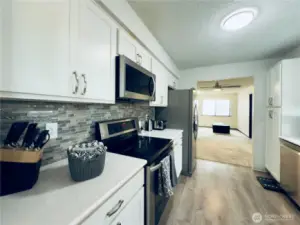 Updated kitchen, white cabinets with pull-out shelvings and pantry. Stainless steel appliances, easy access for entertaining.