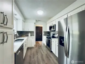Updated kitchen, white cabinets with pull-out shelvings and pantry. Stainless steel appliances, easy access for entertaining.