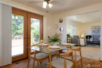 The dining area showcases rich hardwood floors and lovely French doors that open seamlessly to the back patio and yard, creating an ideal flow for indoor-outdoor living.