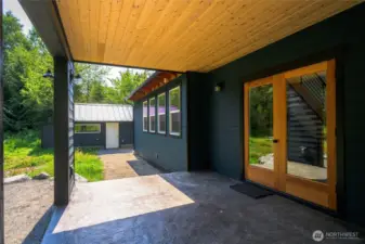 Covered stamped concrete patio with easy access along path to garage.