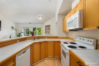 Kitchen: Functional kitchen with ample cabinetry, breakfast bar, and included appliances. Open sightlines to the living room and deck create a seamless flow for everyday living.