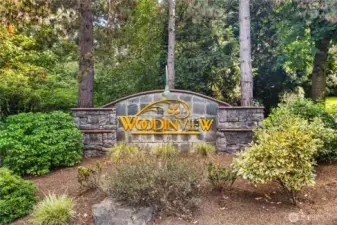 Community Monument: Woodinview’s welcoming entry monument, surrounded by greenery, reflects the established charm and desirable setting of this Bothell condo community.