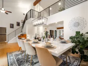 The high ceilings makes the entry way feel grand. A metal railing adorns the staircase and cat walk.