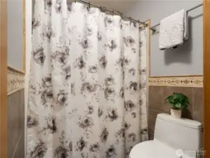 The primary suite full bath on the main level hhas the bathtub/toilet separate from the vanity area.