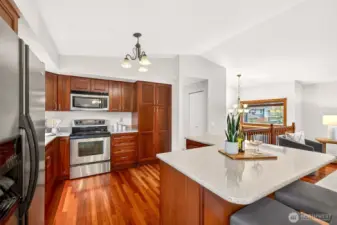 The island is a standout feature, offering expansive solid surface counter space that easily supports entertaining, baking projects, and everyday meals. With the kitchen anchored by warm cabinetry and stainless appliances, the space feels both welcoming and highly functional. This is where conversations naturally happen while dinner comes together and the rest of the home stays in view.