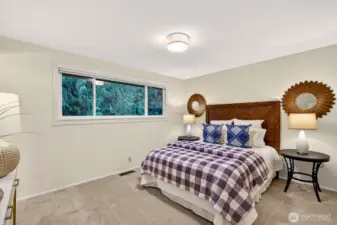 This bedroom feels calm and comfortable, with plush carpet underfoot and a wide window that frames peaceful evergreen views. The space offers flexibility for a relaxing retreat, a reading corner, or a quiet work from home setup. It’s a cozy place to recharge at the end of the day.