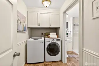 Laundry is refreshingly simple here, with a tucked away washer and dryer, a tile floor that is easy to maintain, and crisp beadboard cabinetry for extra storage. Everything feels clean and organized, so daily routines stay effortless. Having this practical space right where you need it means less clutter, fewer trips up and down, and a smoother flow to your day.