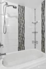 Beautifully tiled bathtub and shower upstairs.