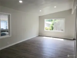 Huge Extra Living Room Area of the Double Wide Home with All New Painted Walls, Trim, Vinyl Plank Flooring Looking from the  Double Door Entry to the Front Covered Front Porch.