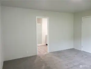 Another View of the Spacious Primary Master Bedroom with Brand New Carpet, Paint, Showing Entry to the Bathroom and the Entry Bedroom Door.