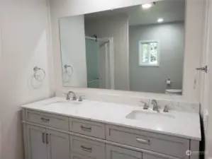 Picture of the roomy Primary Master Bathroom Showing All New Cabinet Vanity, Counter Top, 2 Sinks, Faucets, Paint and Vinyl Plank Flooring.