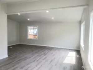 A Different View of the Huge Living Room Area with All New Painted Walls, Cathedral Ceiling, Trim, New Vinyl Windows, Vinyl Plank Flooring Looking from the Front Door Entry to the Front Covered Front Porch.